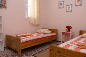 1 dormitorio con 2 camas individuales y ventana en MASTIHA SeaSide Emporios Apartments, en Emporeiós