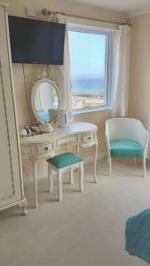 a white dressing table with a mirror and a chair at Palma Guest House in St Ives