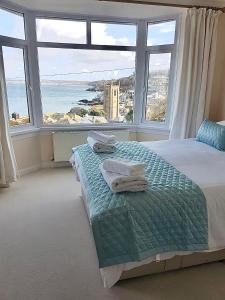 a bedroom with a bed with a view of the ocean at Palma Guest House in St Ives