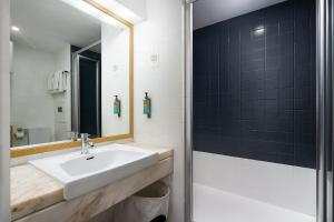 uma casa de banho com um lavatório e um espelho em Cantinho do Mar em Portimão