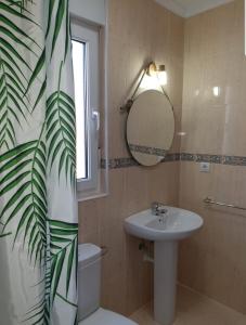 a bathroom with a sink and a toilet and a mirror at Casa vacacional Mirador de San Vicente in Serdió
