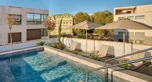 uma piscina no telhado de um edifício com guarda-sóis em Boutique Hotel Luna Granada Centro em Granada