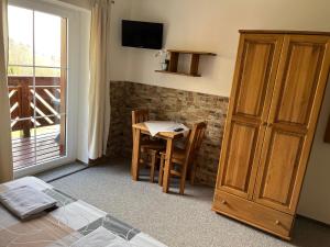 a room with a table and chairs and a television at Na Planýrce in Paseky nad Jizerou