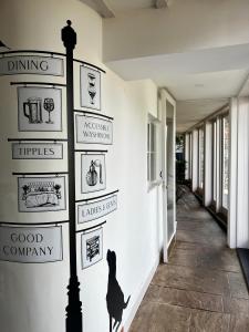 een muur met borden aan de zijkant van een gebouw bij The Lion, Tredington in Shipston on Stour