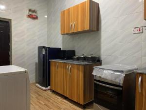 a kitchen with wooden cabinets and a counter top at Luxury 1 Bedroom & Parlor Service Apartment with beautiful Amenities in Awoyaya