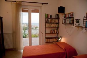 a bedroom with a bed and a book shelf with a window at Appartamento in villa vista mare in Ischia