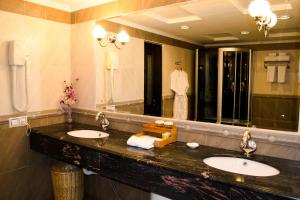 a bathroom with two sinks and a large mirror at Shiny River Hotel in Ustʼ-Kamenogorsk +25 photos