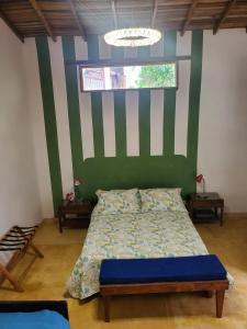 een slaapkamer met een bed met een groene en witte muur bij Villa Nico hospedaje campestre in Bochalema