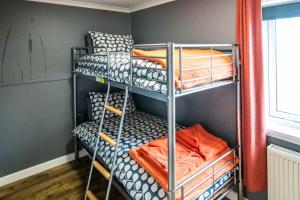 a room with three bunk beds in a room at Burnside Cottage in Wick