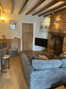 a living room with a couch and a fireplace at The Smithy Cottage in Chilham