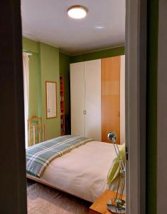 Appartamento CasaZeta luminoso e centralissimo في لاتينا: غرفة نوم بجدران خضراء وسرير كبير