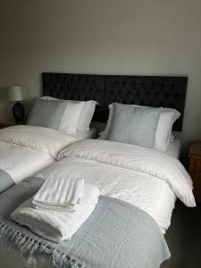 a large white bed with white blankets and pillows at The Smithy Cottage in Chilham