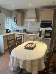 eine Küche mit einem Tisch und einem Tischtuch darauf in der Unterkunft The Smithy Cottage in Chilham