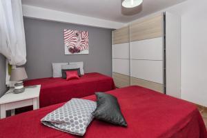 2 camas en un dormitorio con sábanas rojas en Villa Anabela, en Albufeira