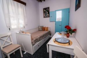 Dormitorio pequeño con cama y mesa en Loukas and Margarita's house en Platís Yialós Sifnos