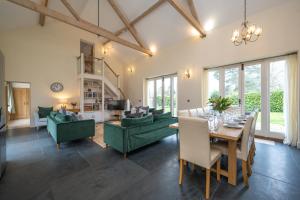 a living room with a table and green furniture at Chestnut Barn, North Norfolk with private hot tub & close to beaches in Norwich