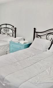 un letto bianco con comodino blu accanto ad esso di 77072 New remodeled Cute Townhome SW a Houston