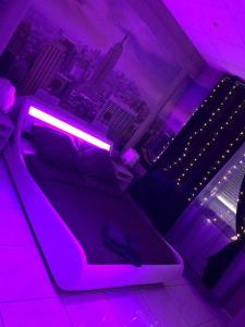 a purple room with a couch with a neon light at Love Paradise by Karen's Room Service in Forbach