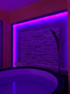 a room with a purple light on a fireplace at Love Paradise by Karen's Room Service in Forbach