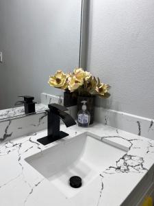 a bathroom with a white counter with a vase of flowers at 77072 New remodeled Cute Townhome SW in Houston