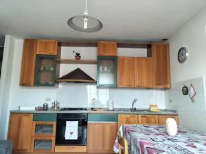 uma cozinha com armários de madeira e um fogão em Appartamento Cologna em Castelfondo