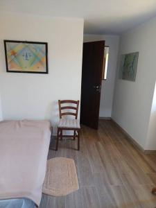 Zimmer mit einem Stuhl, einem Bett und einer Tür in der Unterkunft La corte in Vezzo