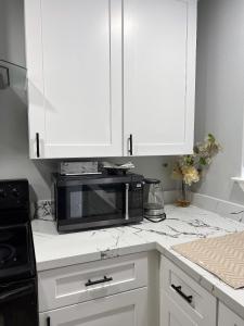 a kitchen with white cabinets and a microwave at 77072 New remodeled Cute Townhome SW in Houston