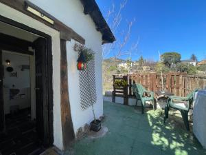 eine Veranda eines Hauses mit einem Tisch und einem Stuhl in der Unterkunft Casa Fidelina II Miraflores de la Sierra in Miraflores de la Sierra