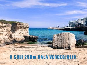 a beach with two large rocks in the water at La casa del Gabbo apartment in Monopoli