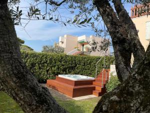 a hot tub in a garden between two trees at Lake Front Apartment - Direct Lake Access in Sirmione