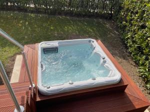 un bain à remous installé sur une terrasse en bois dans l'établissement Lake Front Luxury Suites, à Sirmione