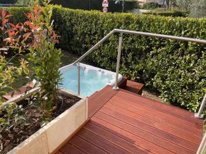 una bañera de hidromasaje en una terraza de madera en Lake Front Luxury Apartment, en Sirmione