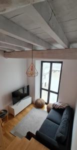 a living room with a couch and a tv at Casa típica Betanzos Casco Histórico in Betanzos