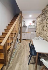 a kitchen with a staircase and a white table and chairs at Casa típica Betanzos Casco Histórico in Betanzos