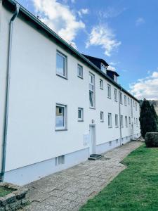 a white building with windows and a grass yard at Monty - Kitchen - Washer - Free Parking - SMART-TV in Goslar