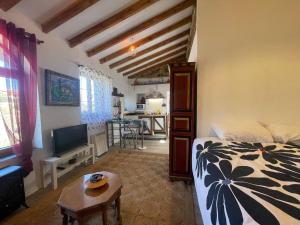 Schlafzimmer mit einem Bett, einem TV und einem Tisch in der Unterkunft Casa Fidelina II Miraflores de la Sierra in Miraflores de la Sierra
