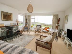 a living room with a fireplace and chairs at Groesffordd in Caernarfon