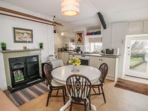 a kitchen with a table and chairs and a fireplace at Groesffordd in Caernarfon