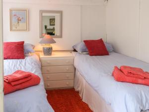 a bedroom with two beds and a night stand with a lamp at Groesffordd in Caernarfon