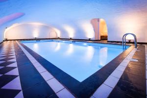 een groot zwembad in een gebouw met een tegelvloer bij Hotel Navarra Brugge in Brugge