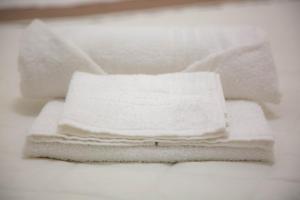 four white towels stacked on top of each other at Piave77 in Bagheria +62 photos