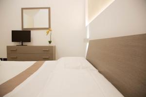 a bedroom with a bed and a tv on a dresser at Piave77 in Bagheria