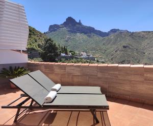 a table and chairs on a balcony with mountains at Vivienda Vacacional La Portada in Tejeda