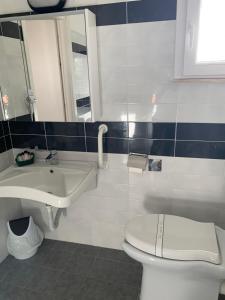 a bathroom with a sink and a toilet and a mirror at Hotel Letizia in Follonica