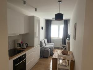 a kitchen and living room with a couch and a table at MW 7B Apartament in Rzeszów