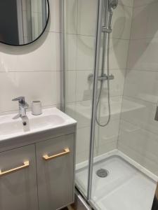 a white bathroom with a shower and a sink at MW 7B Apartament in Rzeszów