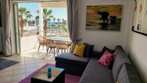 a living room with a couch and a view of the beach at Mare Marina View 2 in Xylokastro