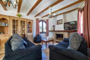 sala de estar con 2 sofás azules y chimenea en Villa Fuster - PlusHolidays, en Calpe