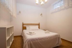 a white bedroom with a bed with two towels on it at Villa Markus - Plusholidays in Calpe +13 photos