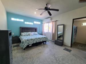 1 dormitorio con 1 cama y ventilador de techo en Palapa rooftop w/ beach views! Cozy Casa Dumas, en Chuburná